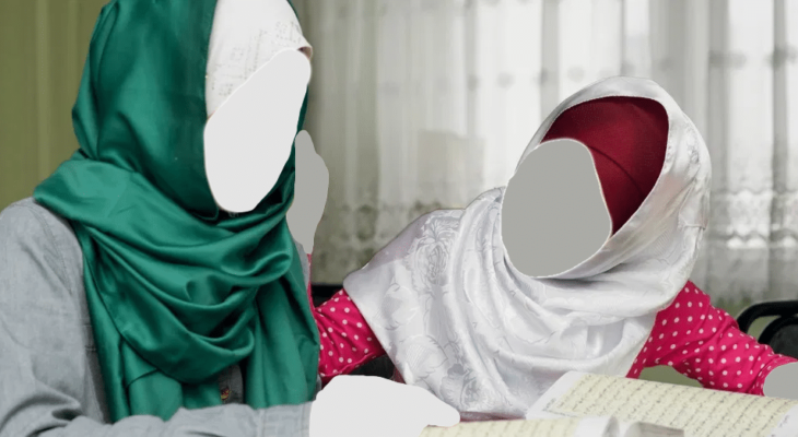 Twee basisschool meisjes met het hoofddoek, gezamenlijk Koran aan het lezen.